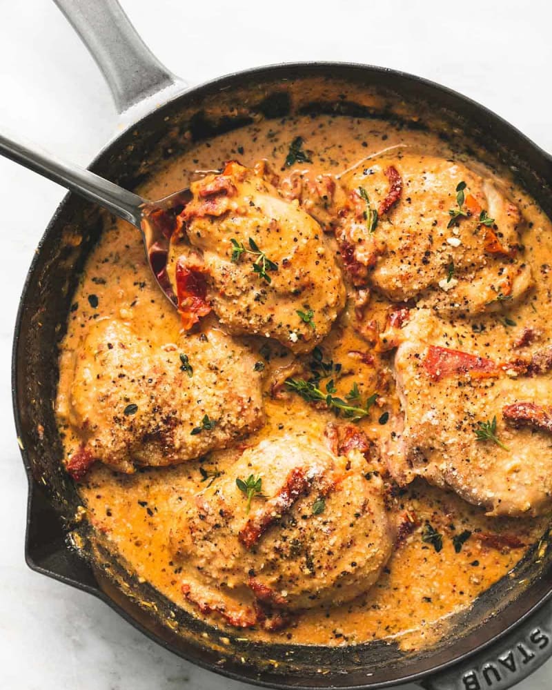 Marry me chicken recipe in a cast-iron skillet: seared chicken in creamy sun-dried tomato sauce with fresh herbs